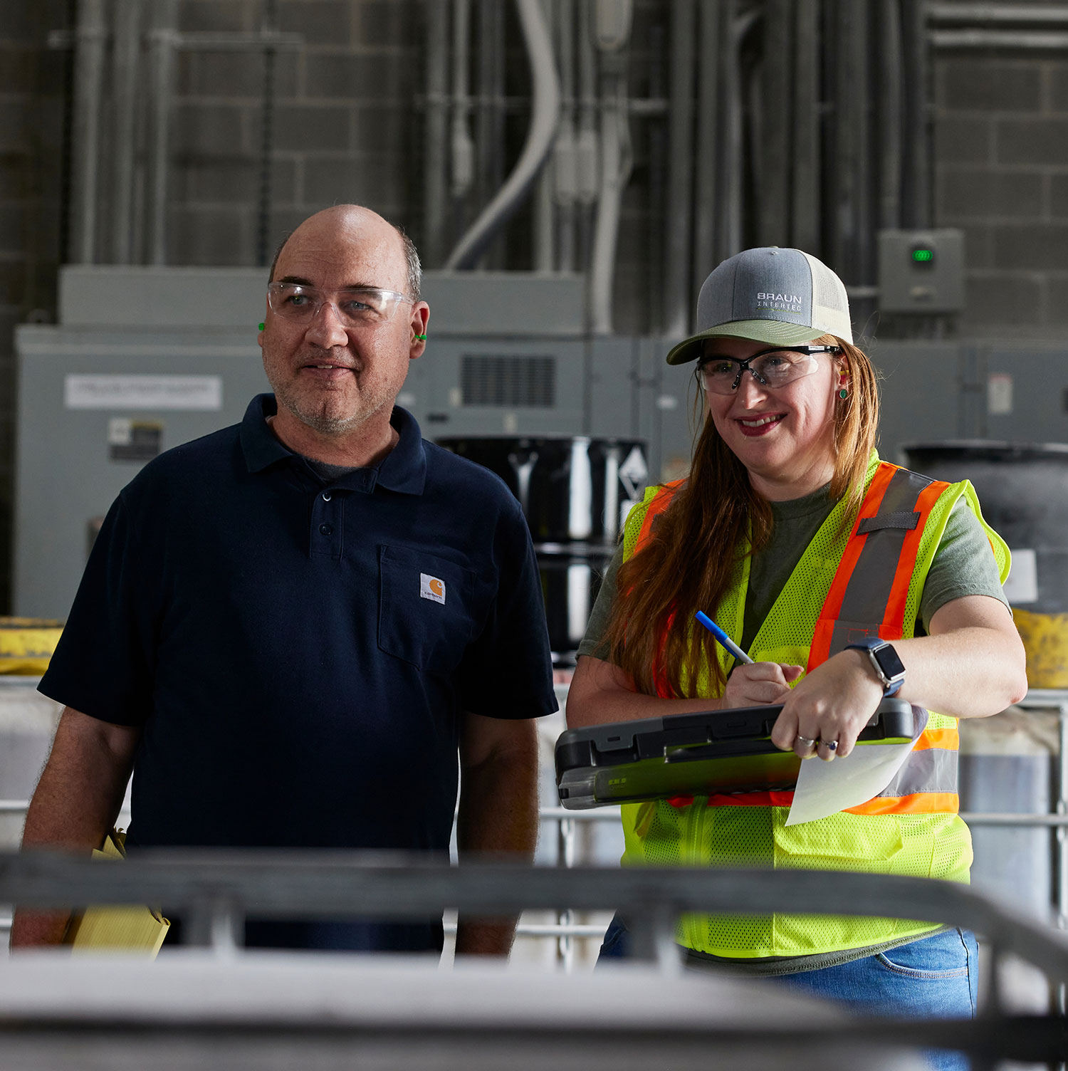 Two workers in a warehouse space smiling