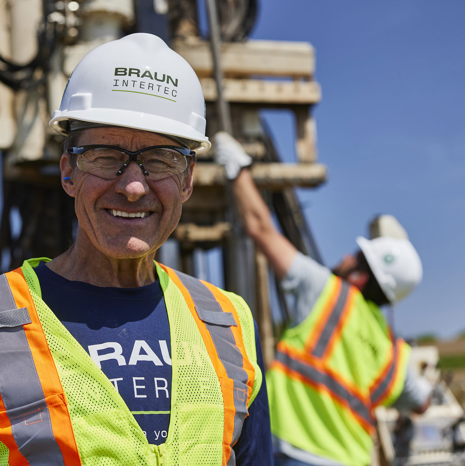 Man in a Braun Intertec hard hat and safety vest on a work site