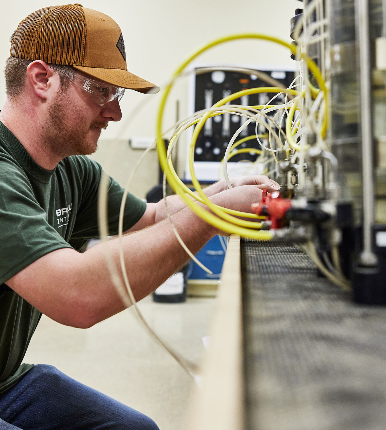 Man in a hat wiring up equipment