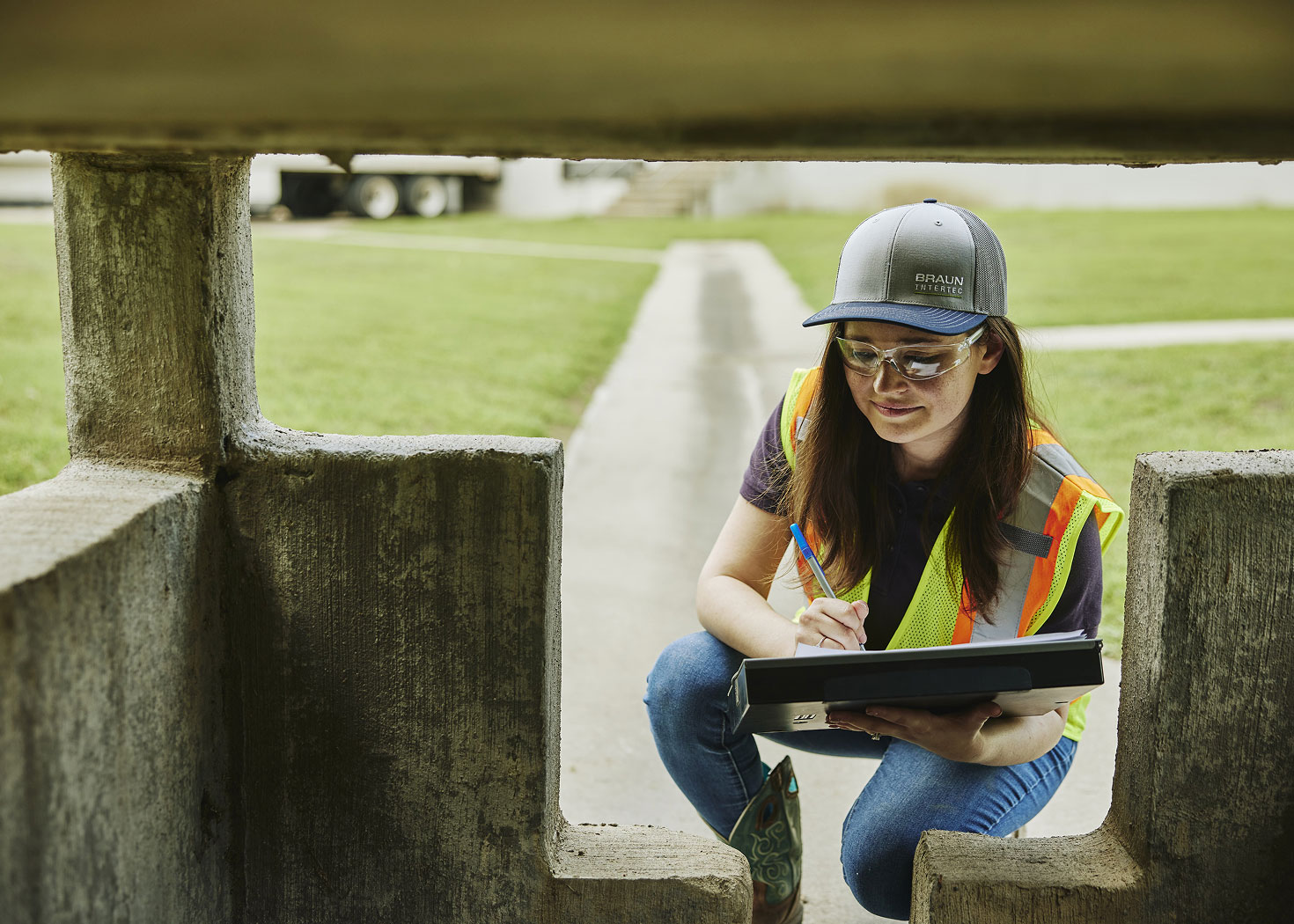 Woman in a hat and safety vest examining foundation