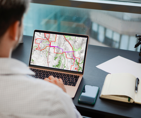 Man sitting in front of a computer with a site map on the screen