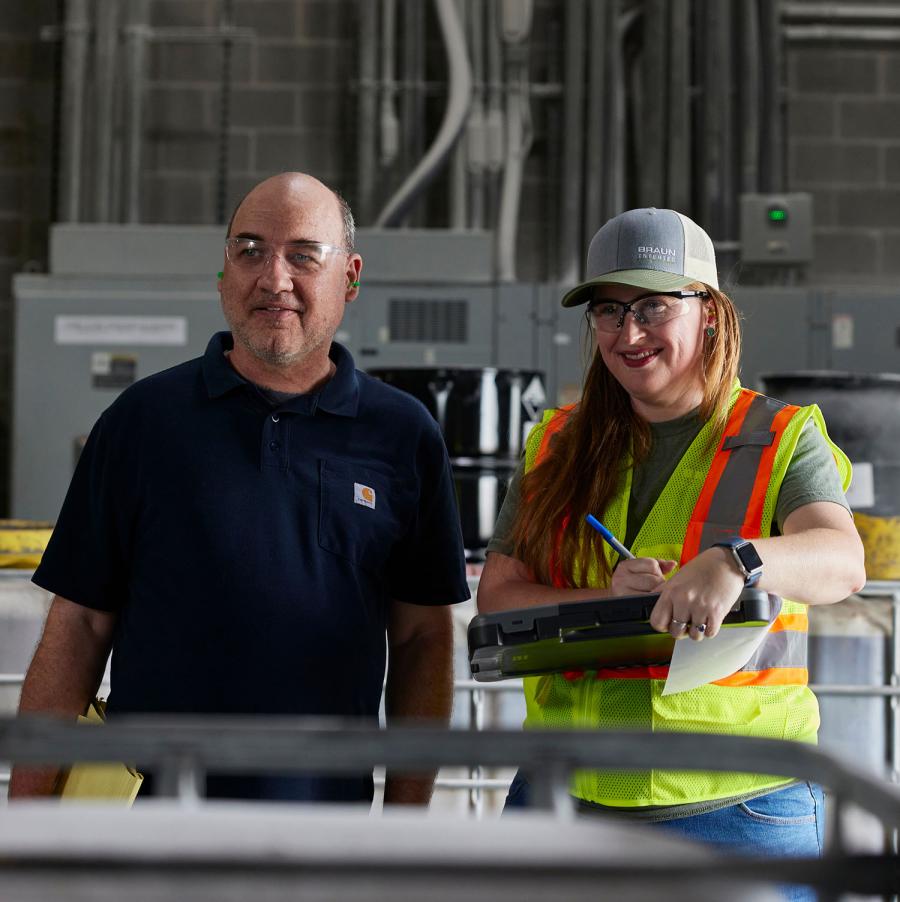 Two workers in a warehouse space smiling