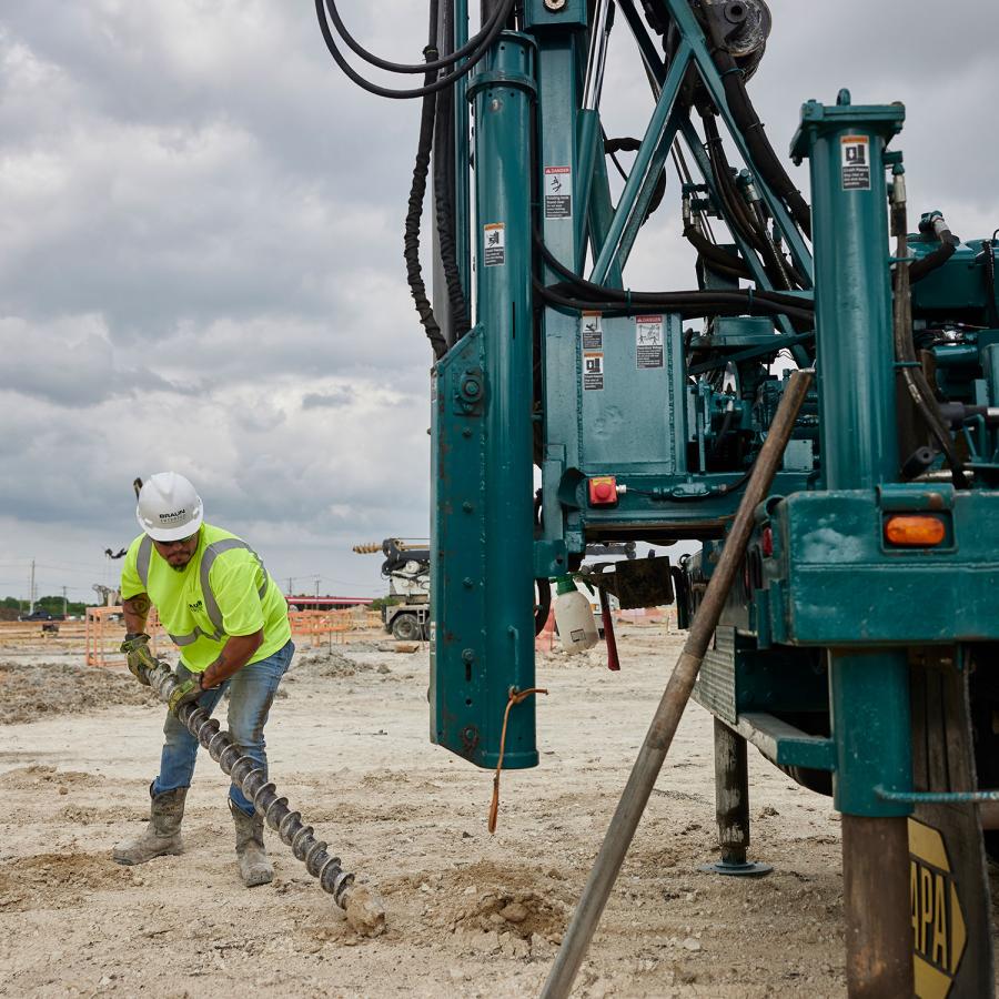 Person in PPE working with a drill rig