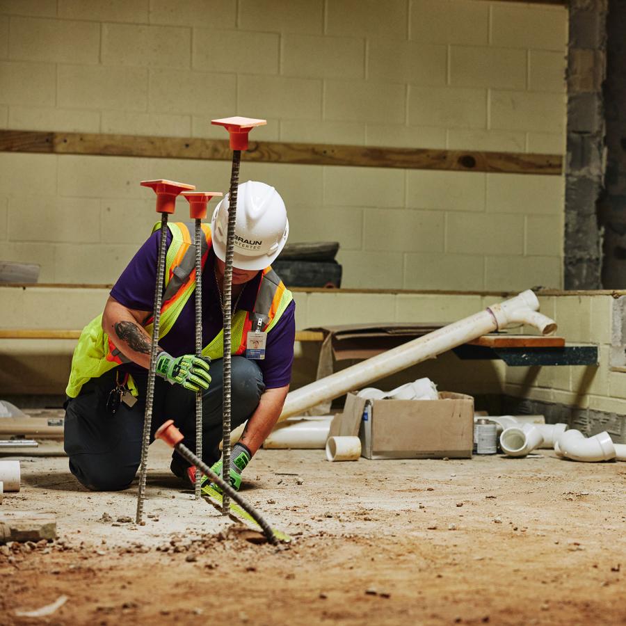 Man in PPE testing rebar on a work site