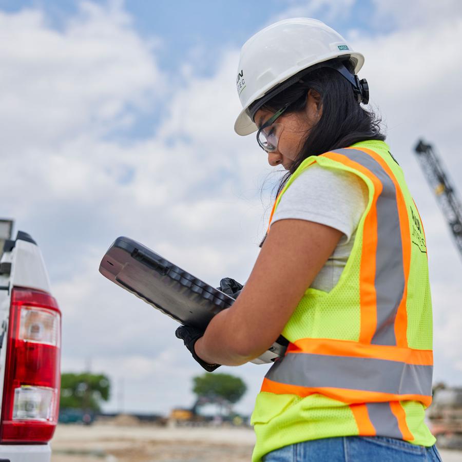 Person taking notes in PPE at a site